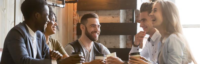 Group_Of_Friends_Laugh_While_Meeting_For_Coffee