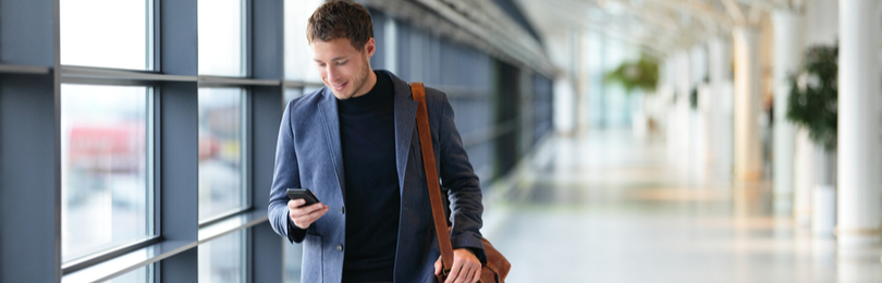 Man_Walking_In_Airport_Viewing_Phone