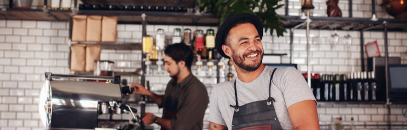 Smiling_Cafe_Owner_Leans_On_Counter