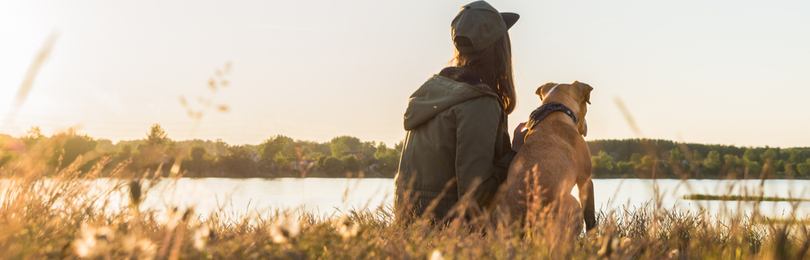 Woman_Sits_With_Dog_Near_Water