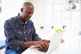 Man On Laptop In Kitchen